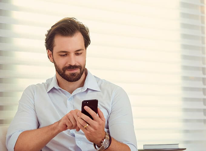 homem no celular para comprar imóvel