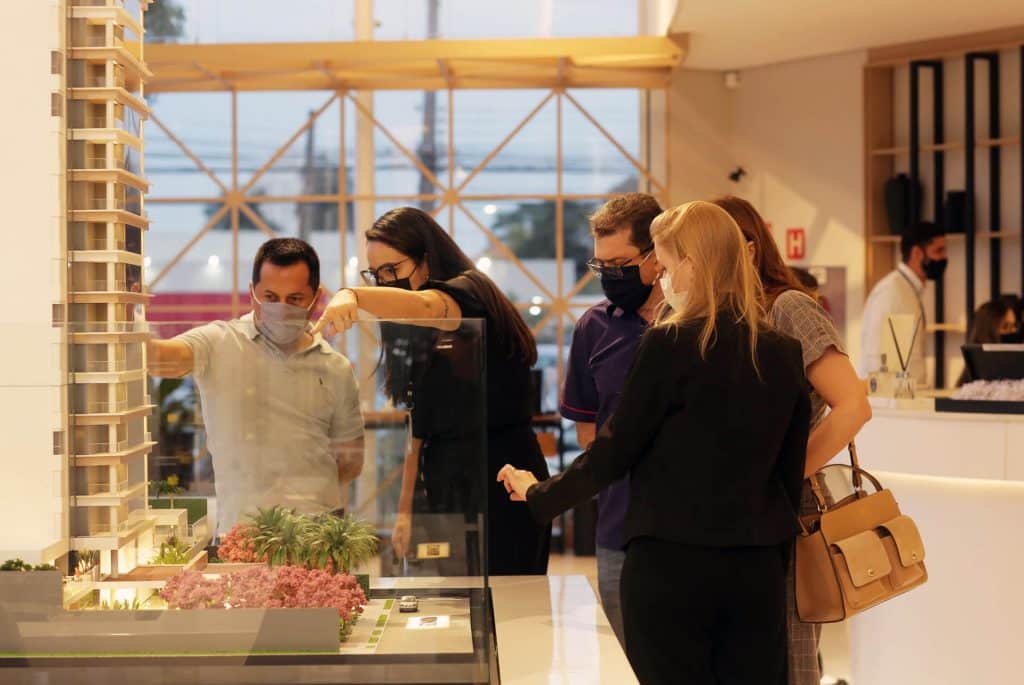 Clientes vendo a maquete do novo empreendimento de alto padrão, Scenarium