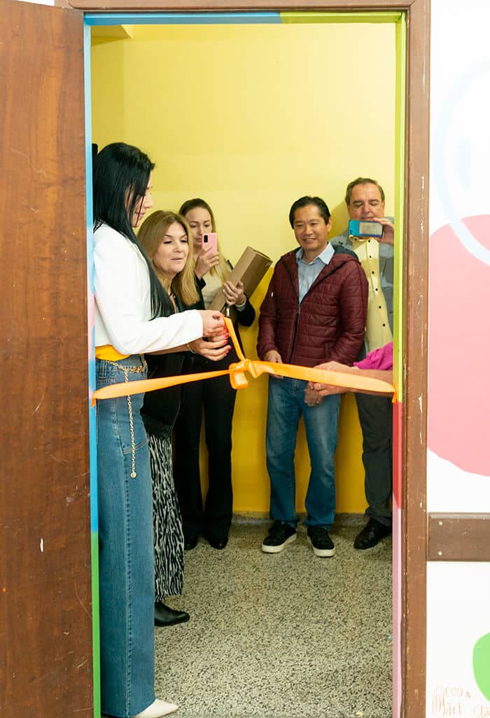 pessoas cortando o laço de inauguração da sala da escola