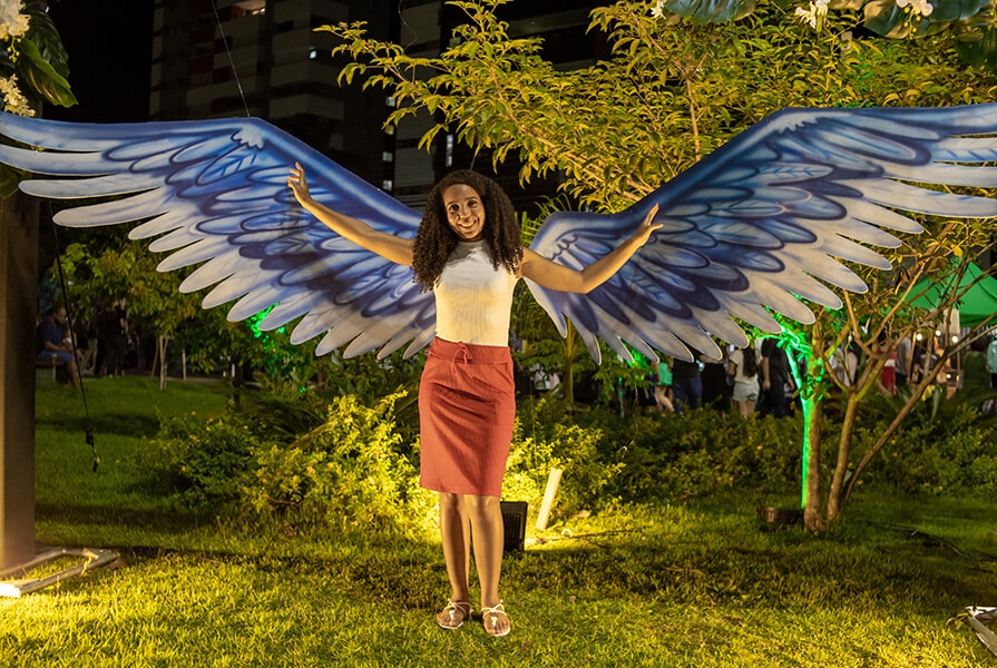 mulher em espaço para tirar foto com asas no evento food truck