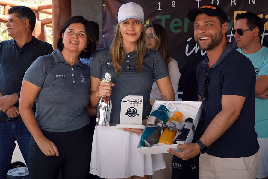 mulher recebe premio do torneio de golfe 