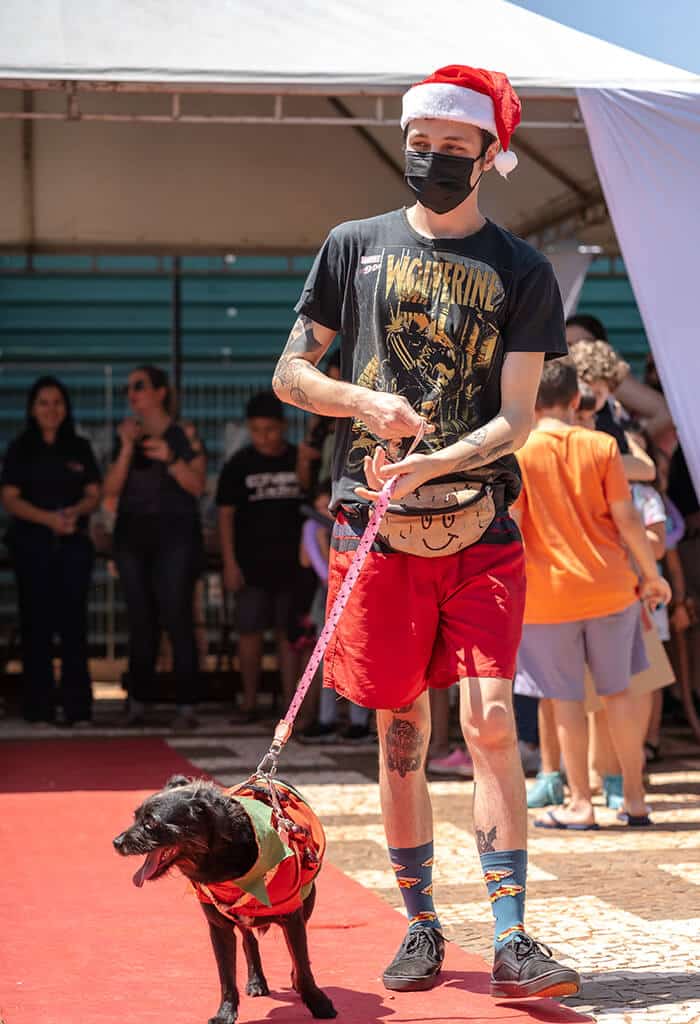 homem desfila com cachorro vestido de natal