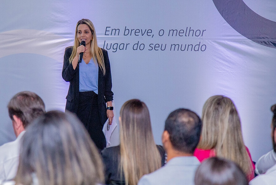 mulher falando em microfone em evento