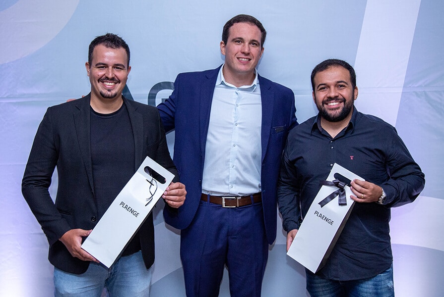 tres homens segurando sacolas no evento aerie