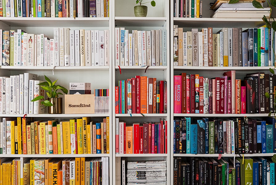 Estante de livros organizada por cores, biblioteca particular