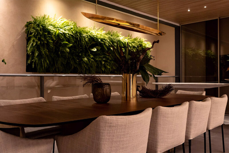 Mesa de jantar moderna com plantas na parede