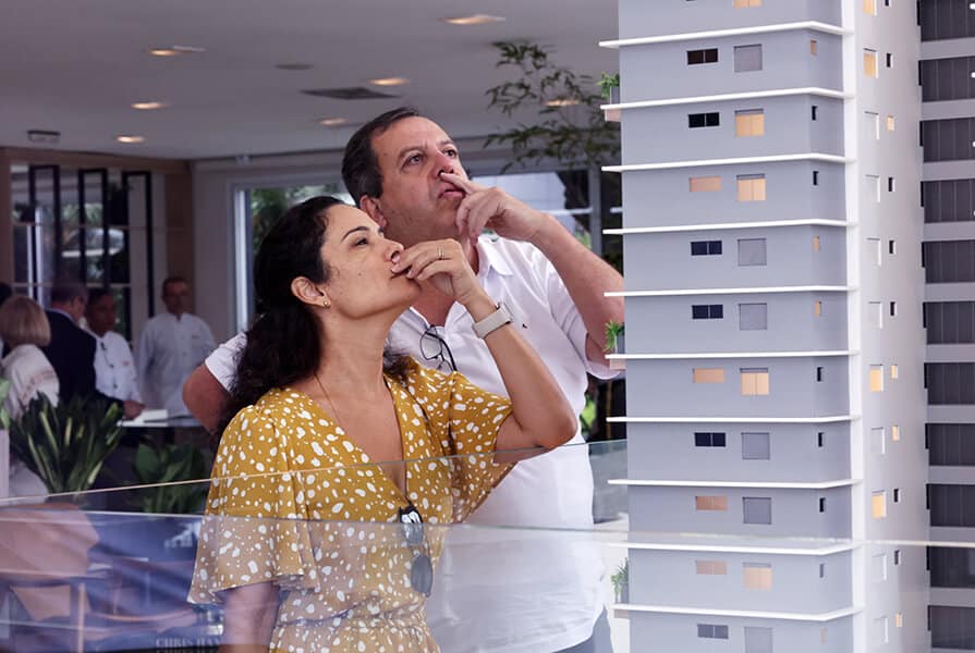 casal conferindo a maquete no lançamento do Aztris