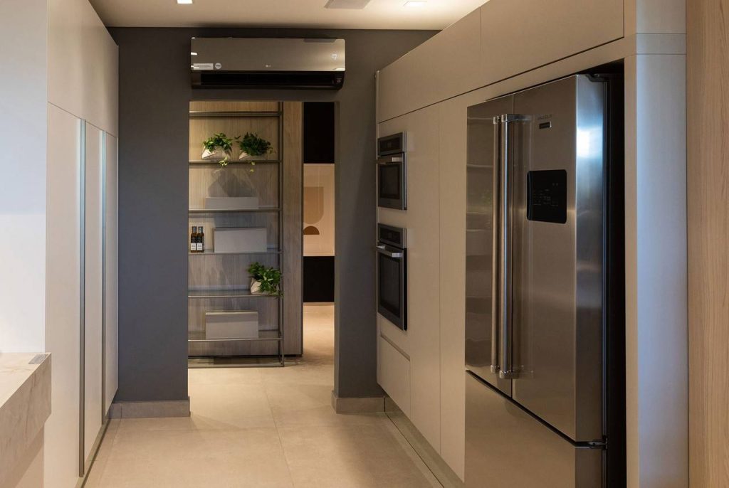 cozinha moderna e minimalista com refrigerador duas portas em inox e eletrodomésticos embutidos