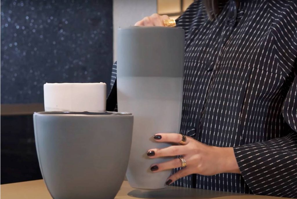 mulher segurando um vaso de cerâmica