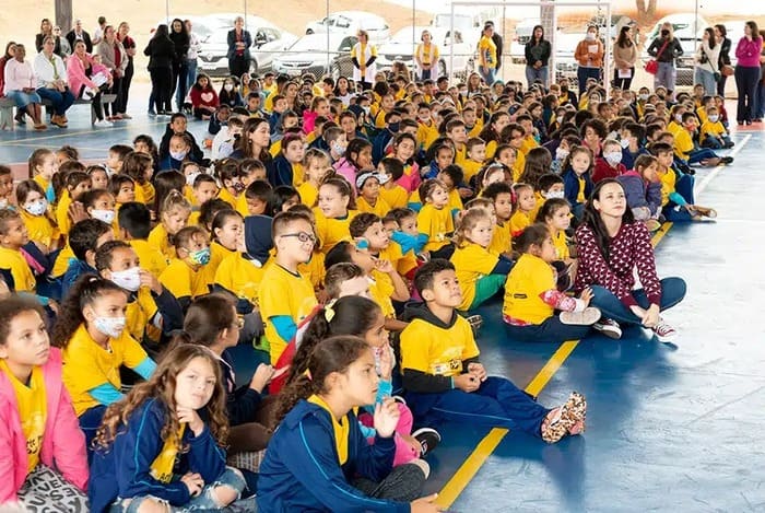 crianças sentadas no chao da escola