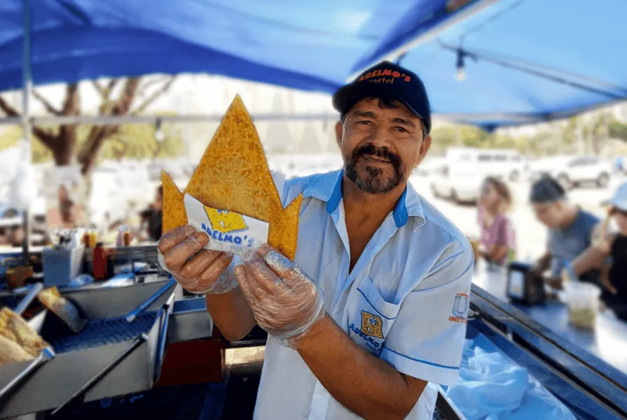 homem segura pastel em formato de triangulo