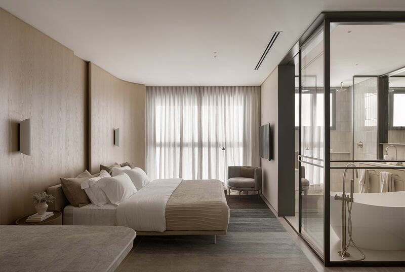 Quarto moderno com cama e banheiro de vidro