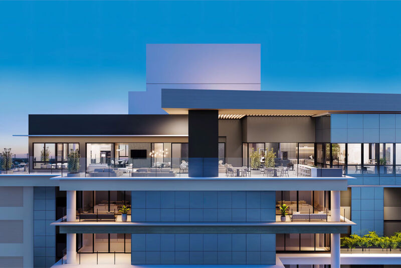 Edifício moderno com varandas expansivas ao entardecer.