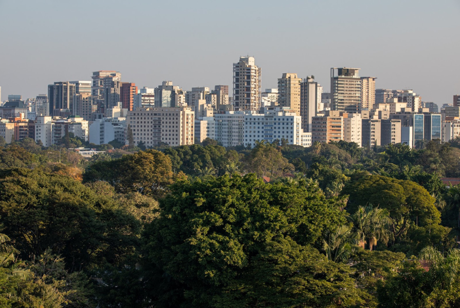 Vista do bairro Jardins, em São Paulo. Com uma ampla área urbana composta por inúmeros prédios e uma vegetação exuberante verde.