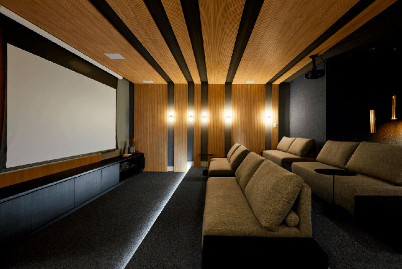 Sala de cinema com sofás confortáveis e tela grande