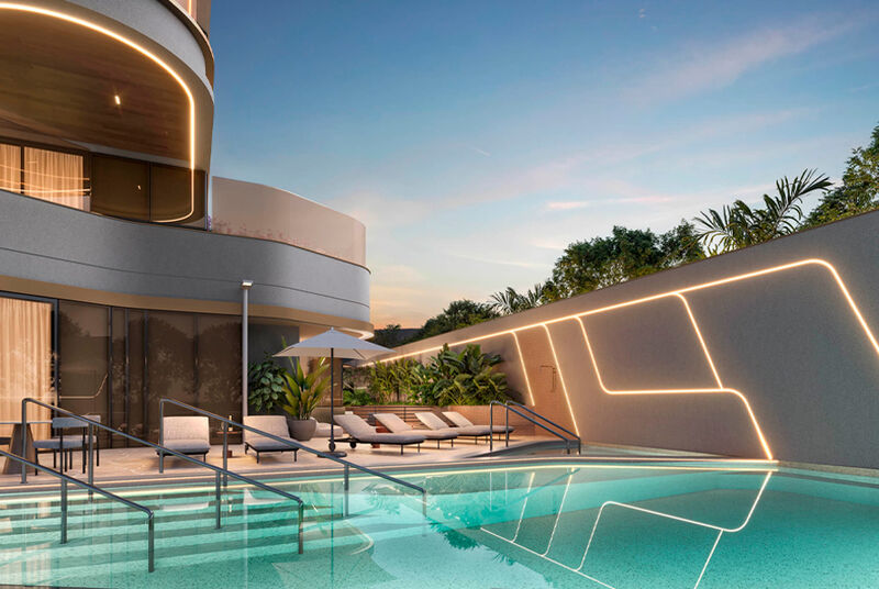 Área de lazer com piscina e espreguiçadeiras ao entardecer