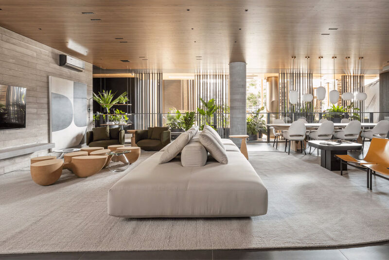 Sala moderna com sofás, mesas e plantas decorativas