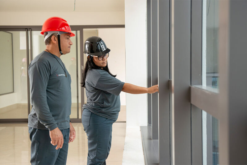 Trabalhadores em construção verificando janela