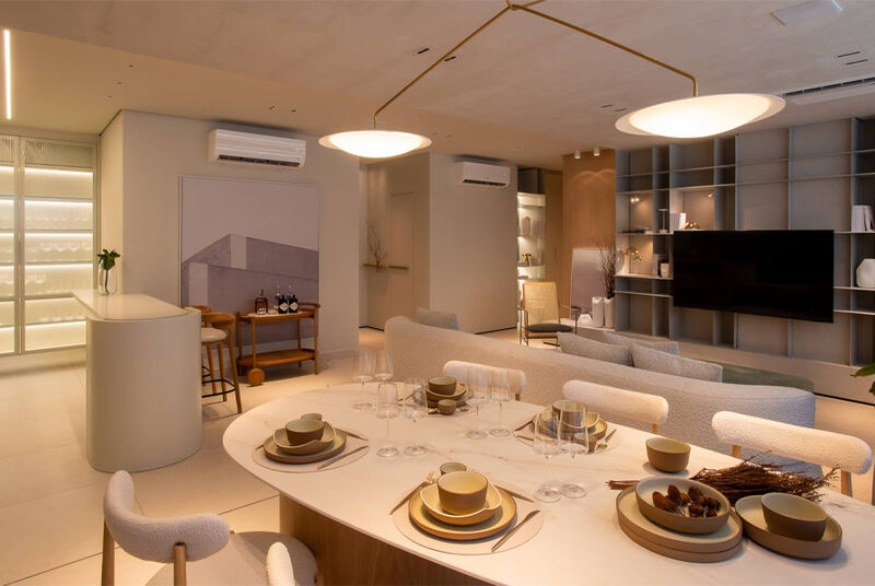 Sala moderna com mesa posta e área de estar.