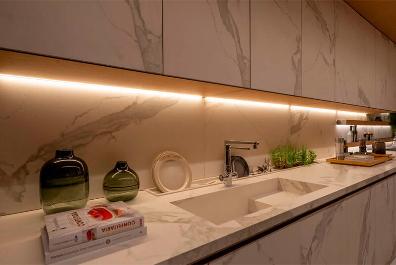 Cozinha moderna com bancada de mármore e iluminação suave