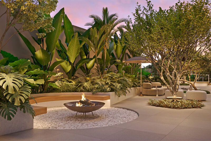 Jardim moderno com fogueira e plantas tropicais