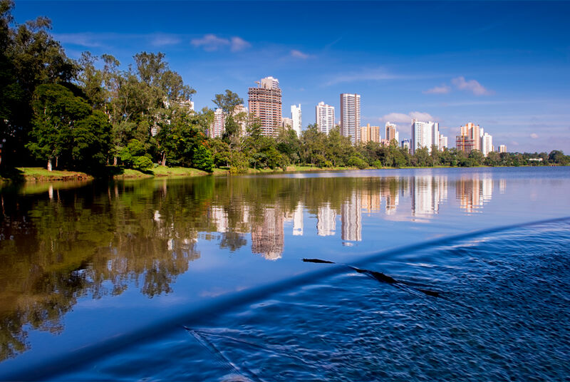Reflexo de prédios em lago com céu azul