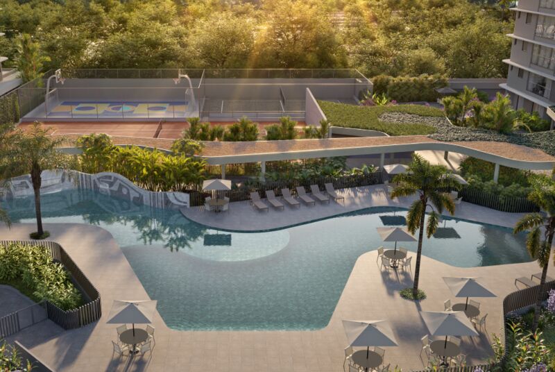 Vista aérea de piscina com áreas verdes e quadra de esportes.