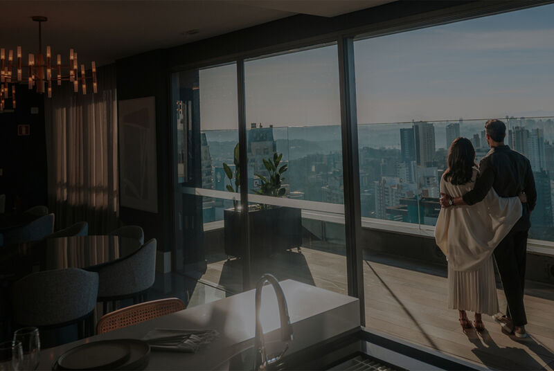 Casal admirando a vista de um apartamento moderno